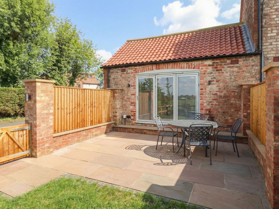 An outdoor area with a table and chairs at Stable End Cottage Cuckoo Nest Farm near Wilberfoss
