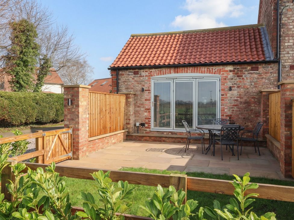 A garden with a table and chairs at Stable End Cottage Cuckoo Nest Farm near Wilberfoss