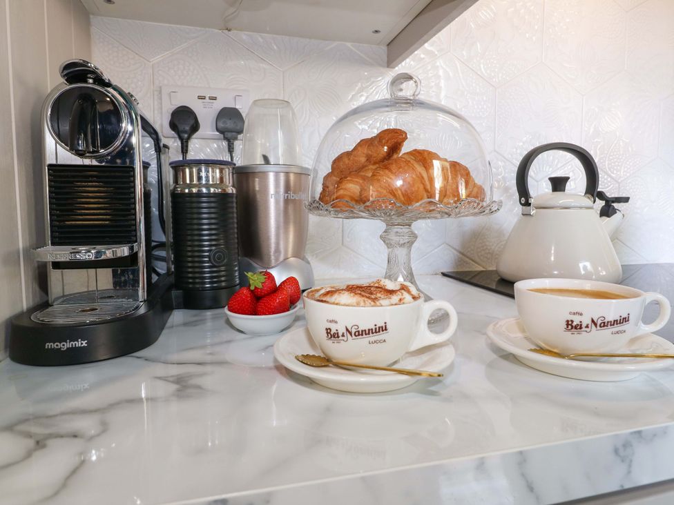 A kitchen countertop with coffee cups, croissants, and strawberries at 83 Meeting Street Quorn