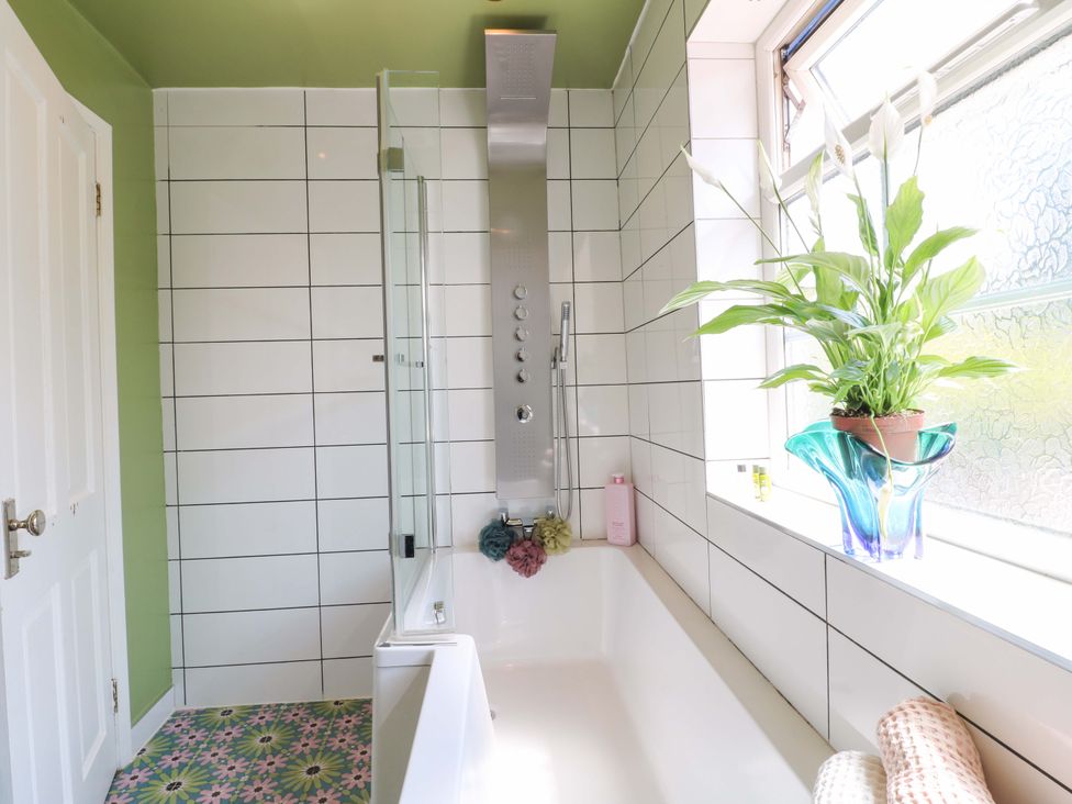 A bathroom with a bathtub and shower panel at 83 Meeting Street in Quorn