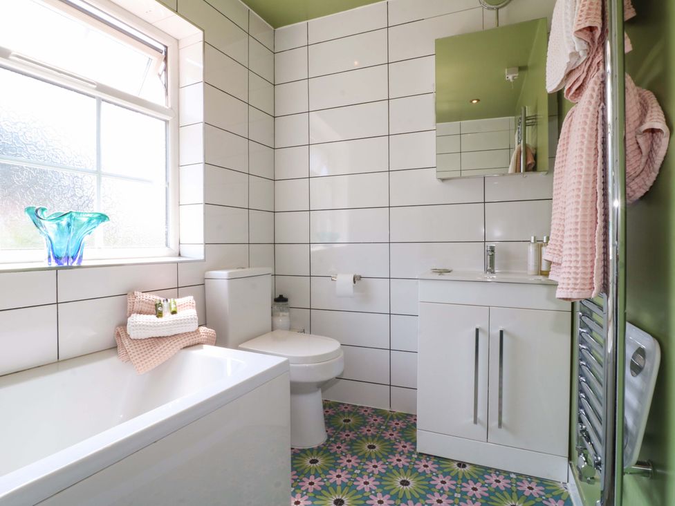 A bathroom with a bath tub, toilet, and sink at 83 Meeting Street in Quorn