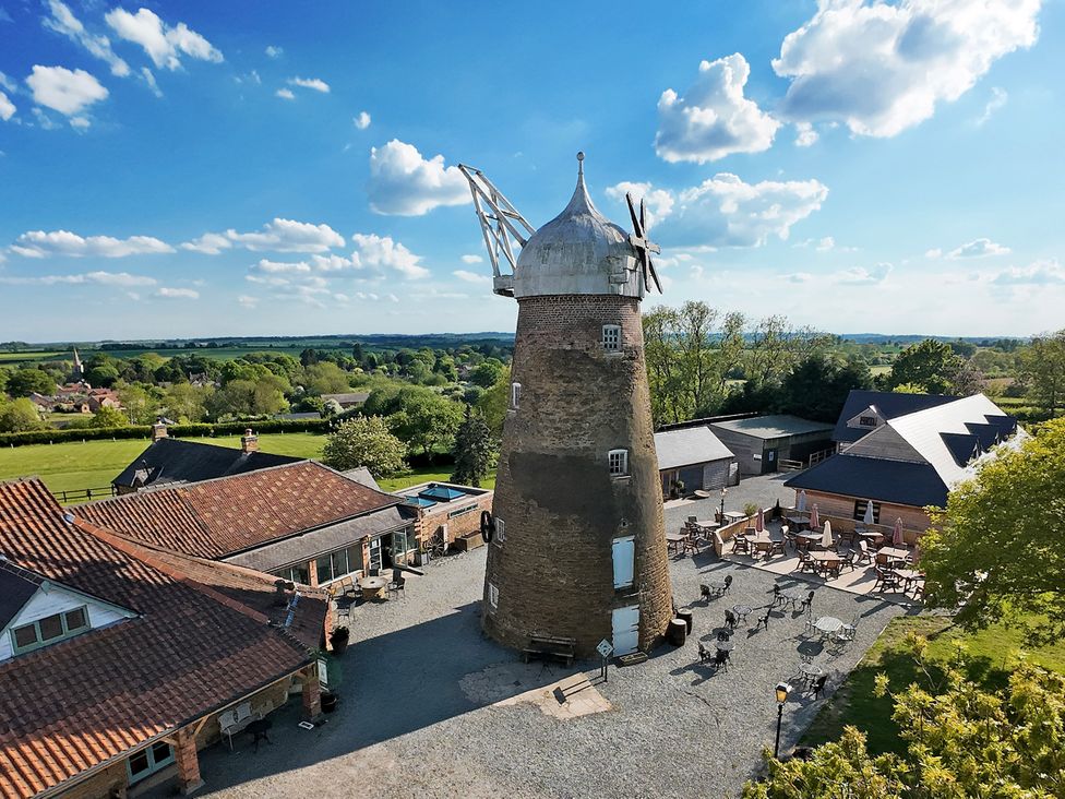 An outdoor area with a windmill and seating at The Oak Room - Windmill Country Retreats Wymondham near Buckminster