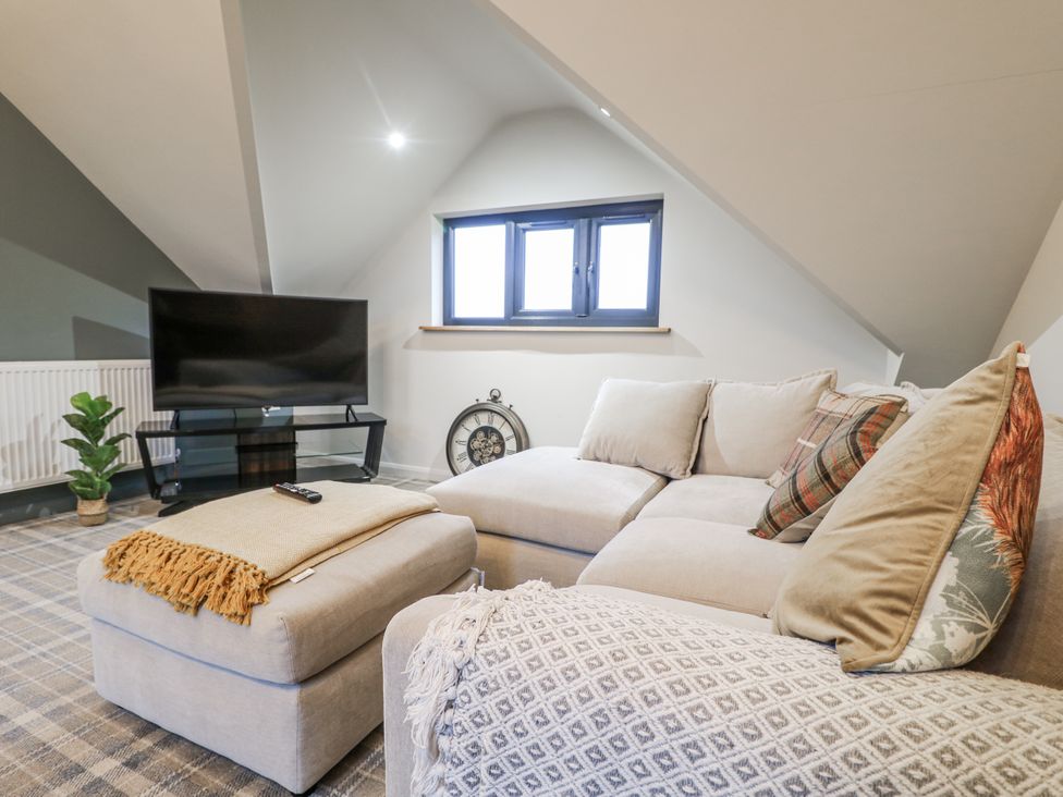 A living room with a sofa and television at The Walnut Room - Windmill Country Retreats Wymondham near Buckminster