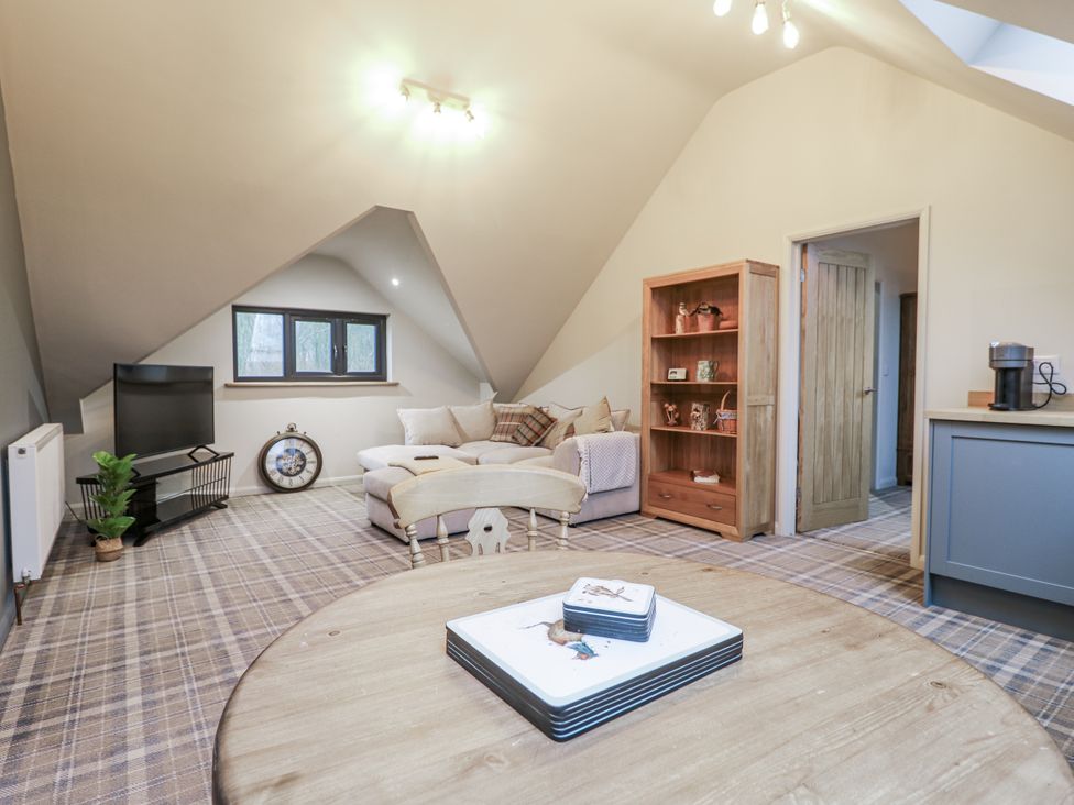 A snug with a television and sofa at The Walnut Room - Windmill Country Retreats Wymondham near Buckminster