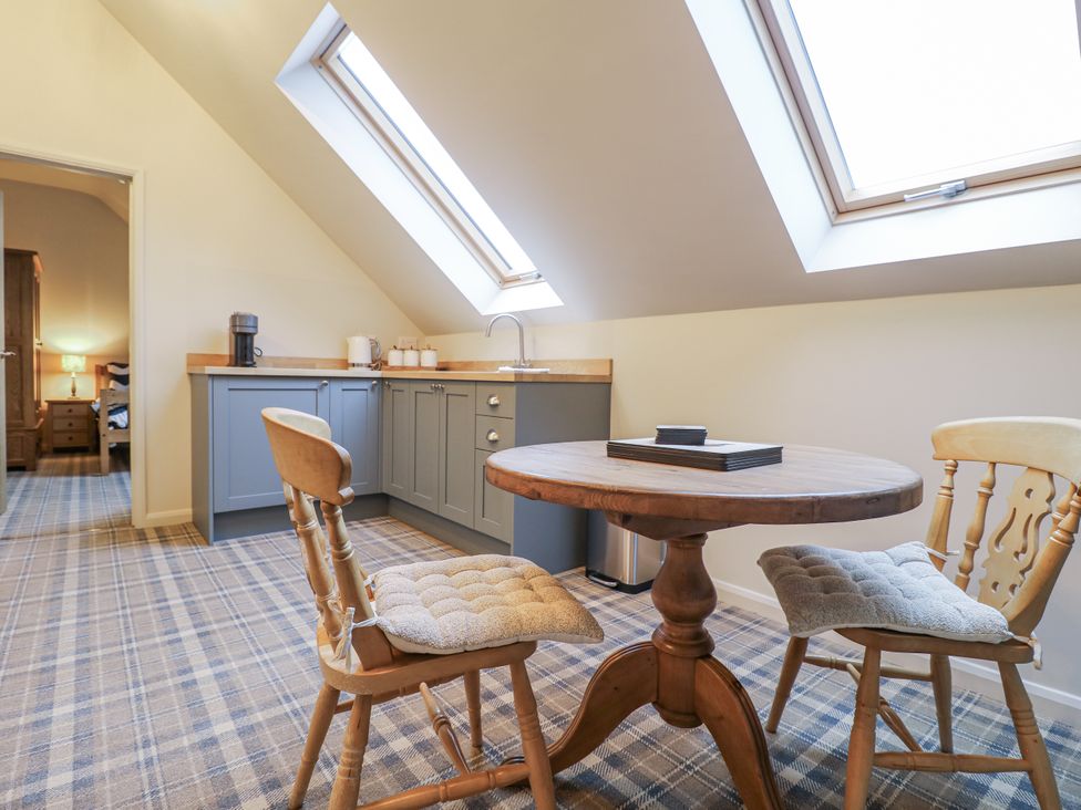 A kitchenette with a table and chairs at The Walnut Room - Windmill Country Retreats Wymondham near Buckminster