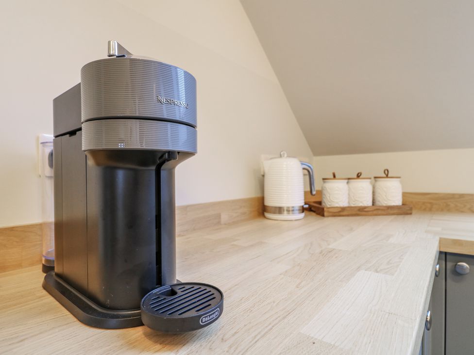 A coffee machine and kettle on a kitchen countertop at The Walnut Room - Windmill Country Retreats Wymondham near Buckminster