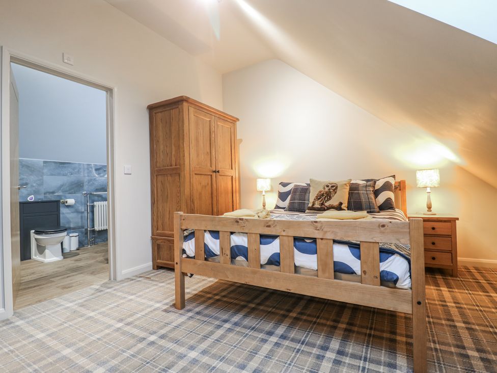 A bedroom with a bed and wardrobe at The Walnut Room - Windmill Country Retreats