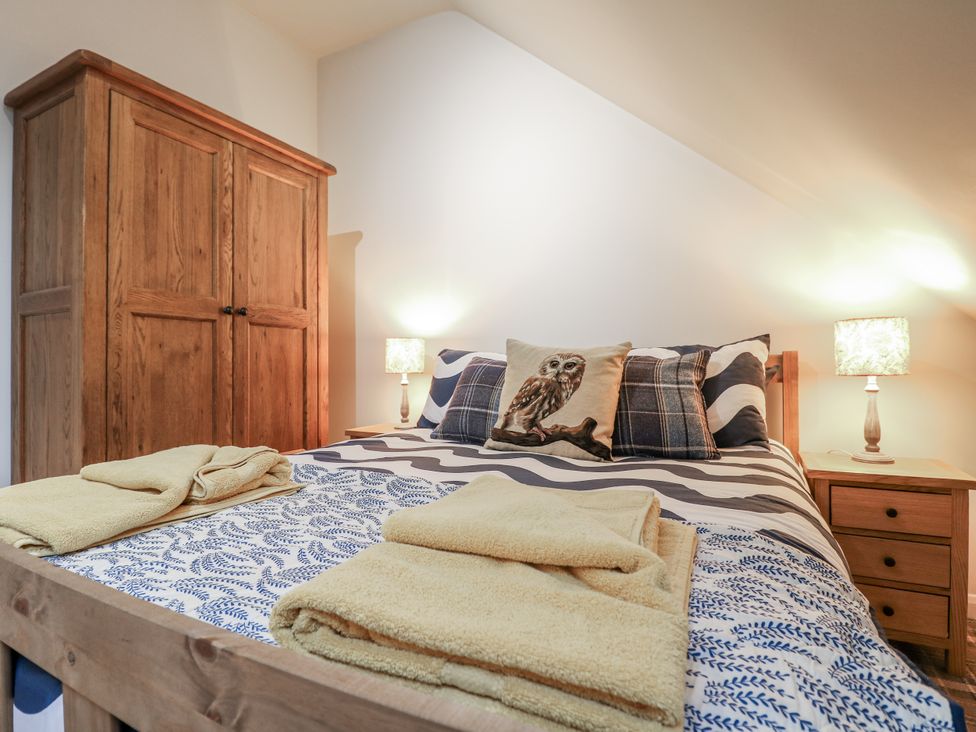 A bedroom with a bed and wardrobe at The Walnut Room - Windmill Country Retreats Wymondham near Buckminster