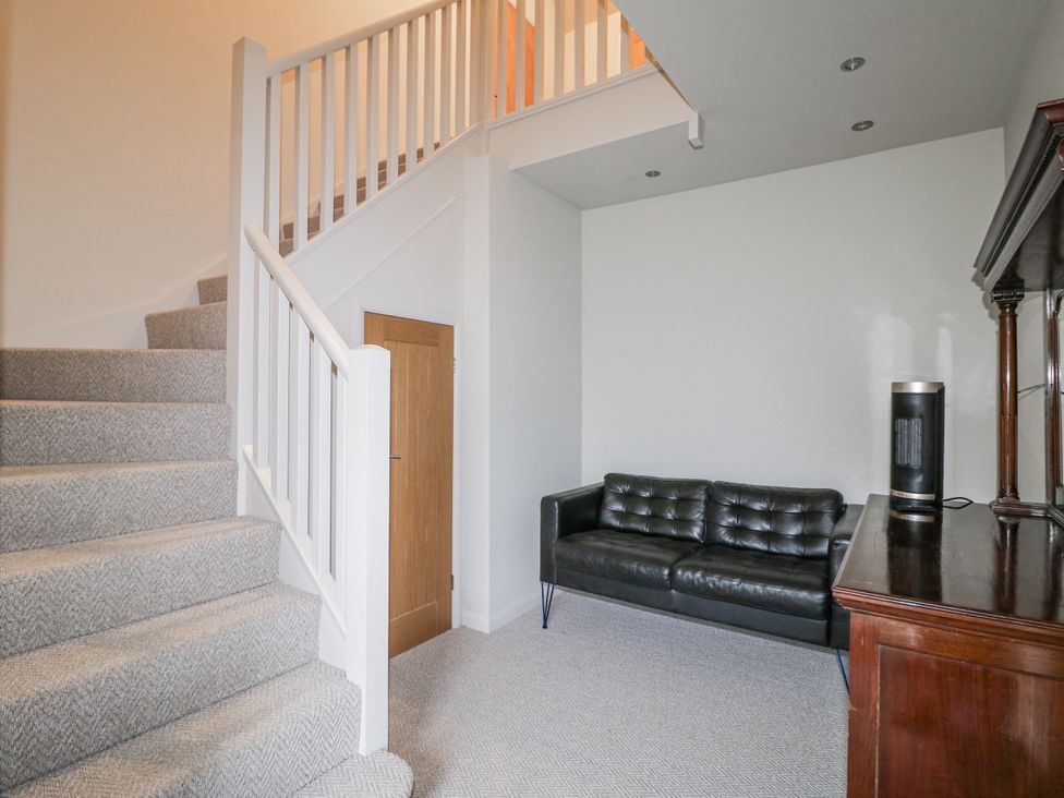 A landing with a sofa and staircase at The Walnut Room - Windmill Country Retreats Wymondham near Buckminster