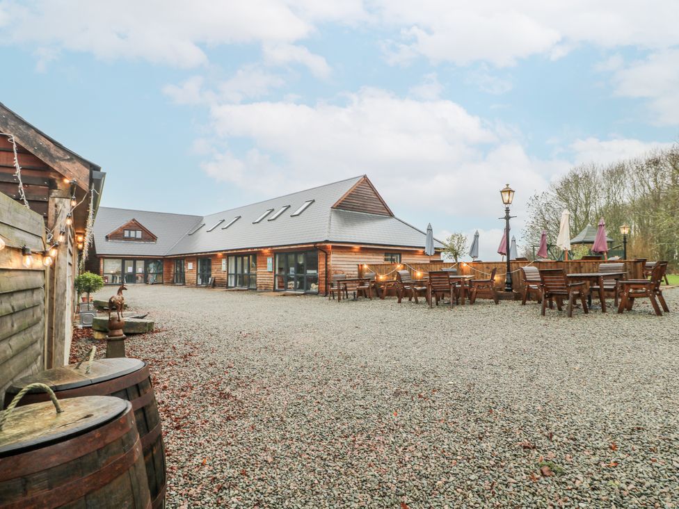 An outdoor seating area with wooden tables at The Walnut Room - Windmill Country Retreats Wymondham near Buckminster
