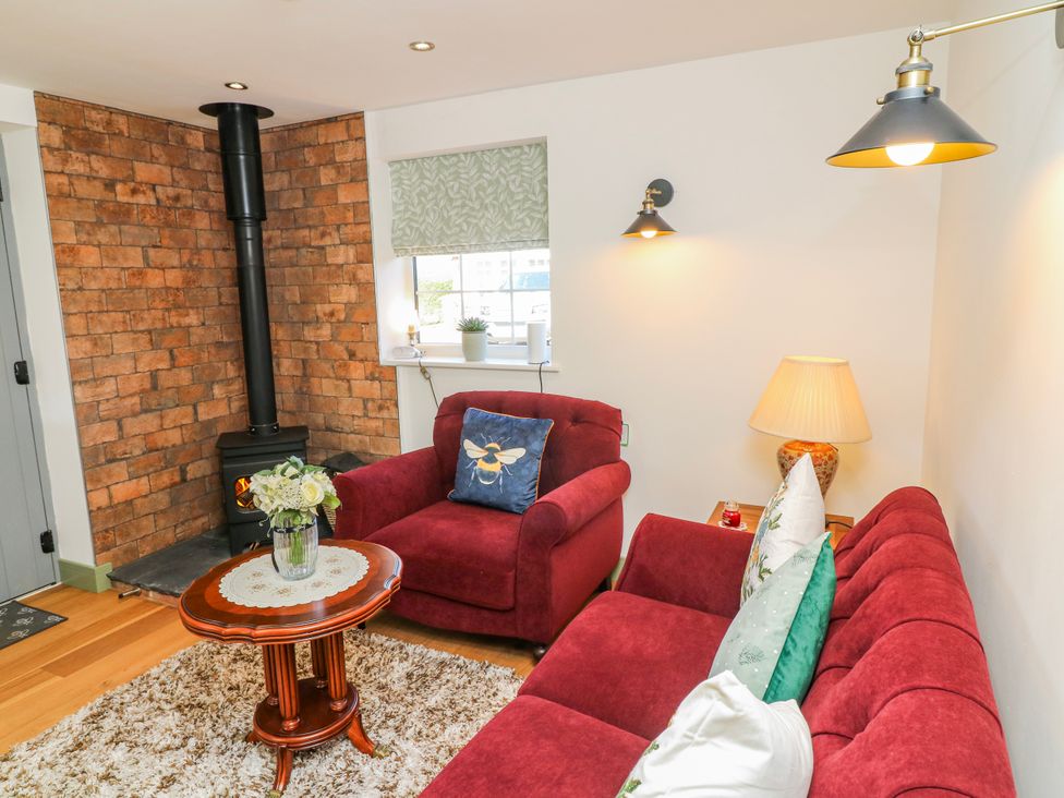 A living room with a sofa, coffee table, and wood stove at Frog Leap in Scunthorpe