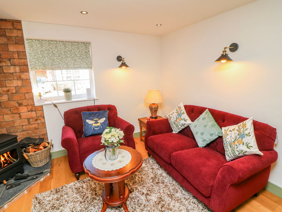 A living room with red furniture and a fireplace at Frog Leap in Scunthorpe