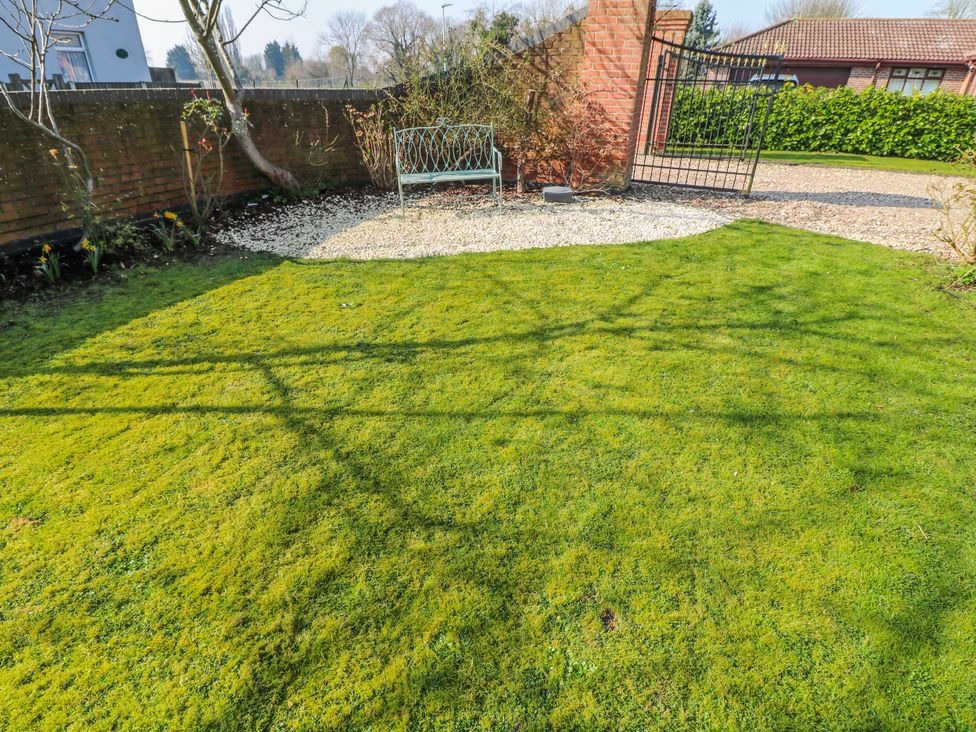 A garden with a bench and pathway at Frog Leap in Scunthorpe