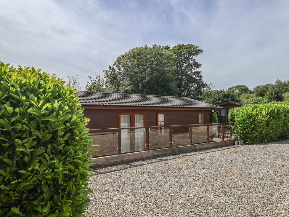 A building with windows and a railing surrounded by gravel at Newton Calm in Newton Ferrers