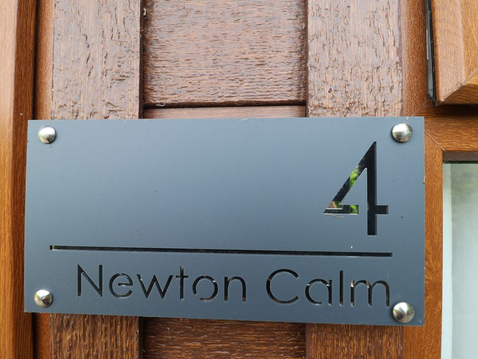 An address plaque with number 4 and Newton Calm at Newton Ferrers