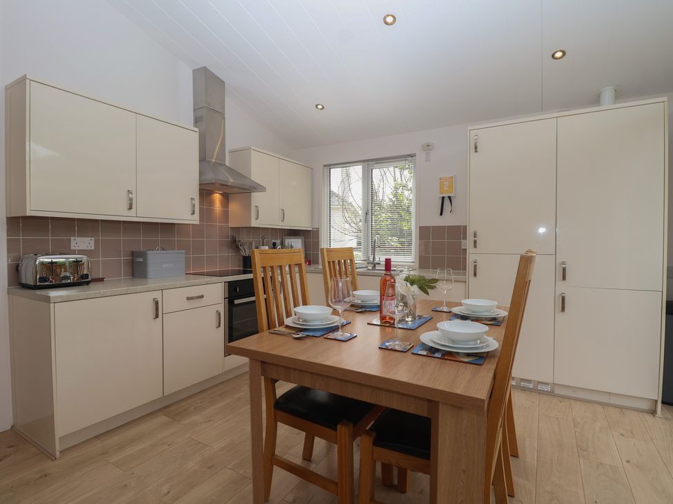 A kitchen with table and chairs at Newton Calm in Newton Ferrers