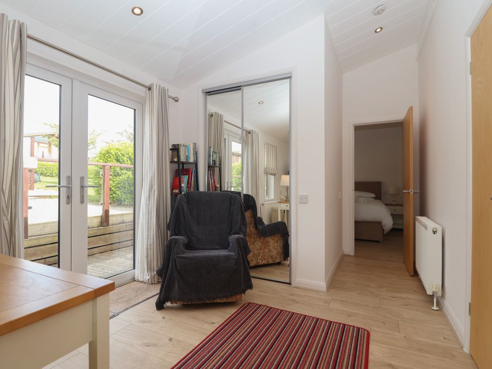 A hallway with double doors and a chair at Newton Calm in Newton Ferrers