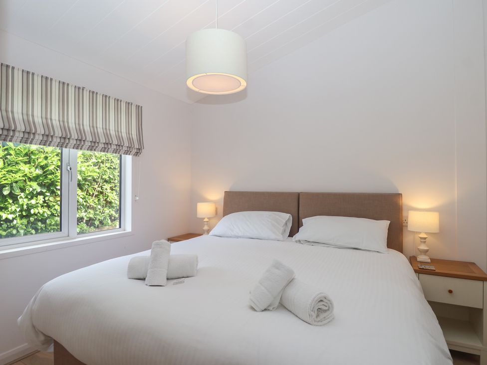 A bedroom with a bed and bedside lamps at Newton Calm in Newton Ferrers