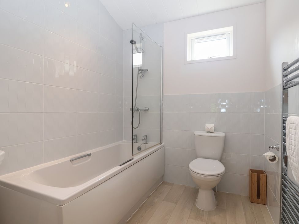 A bathroom with a bath tub and shower at Newton Calm in Newton Ferrers