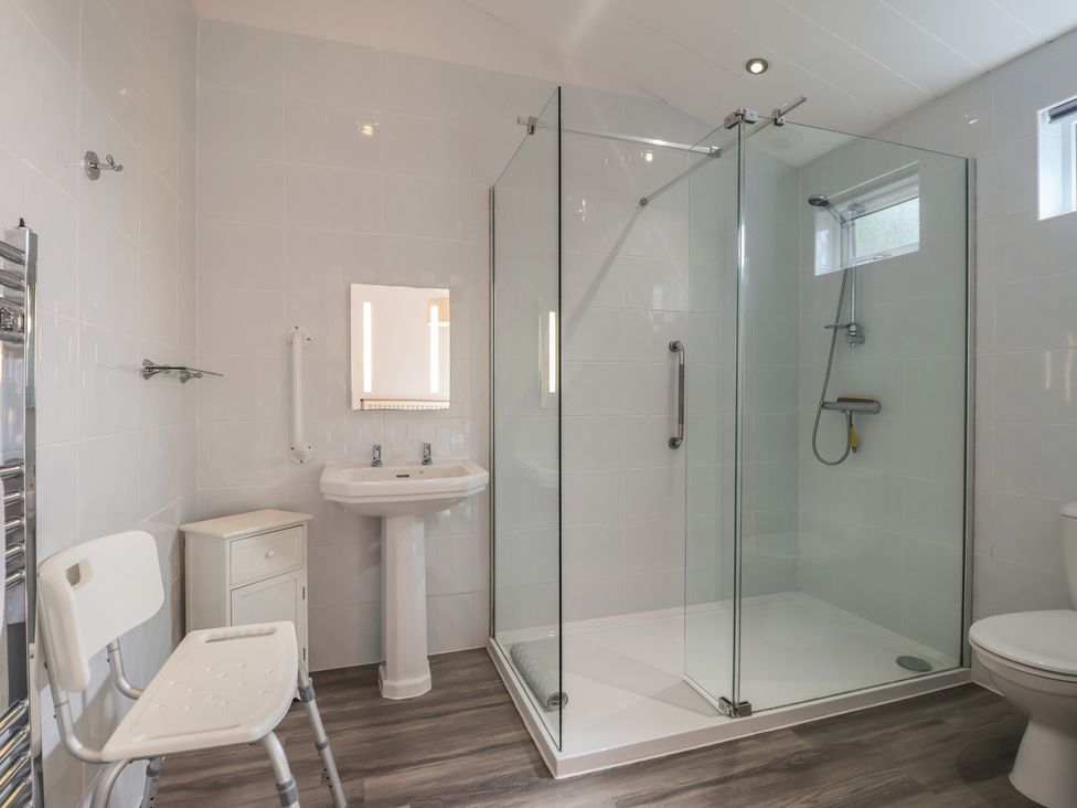 A bathroom with a shower, sink, and toilet at Newton Calm in Newton Ferrers
