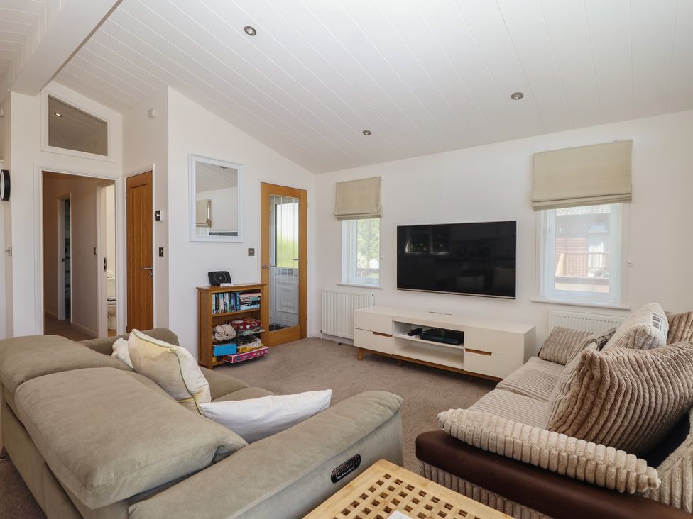 A living room with a television and sofa at Skyview in Newton Ferrers