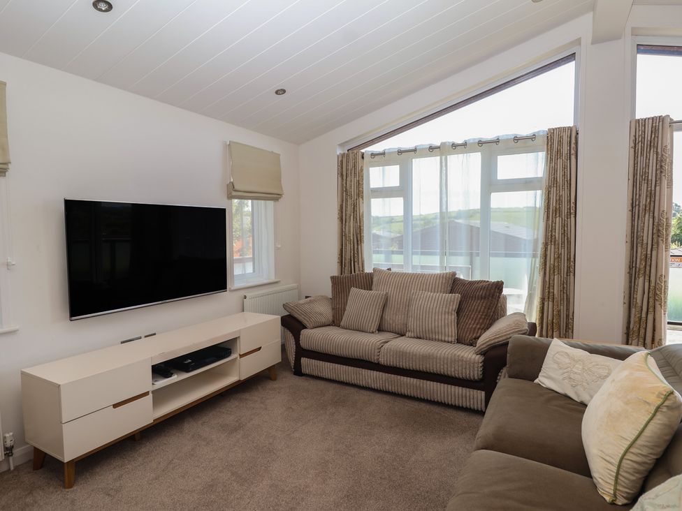 A living room with a sofa and television at Skyview in Newton Ferrers