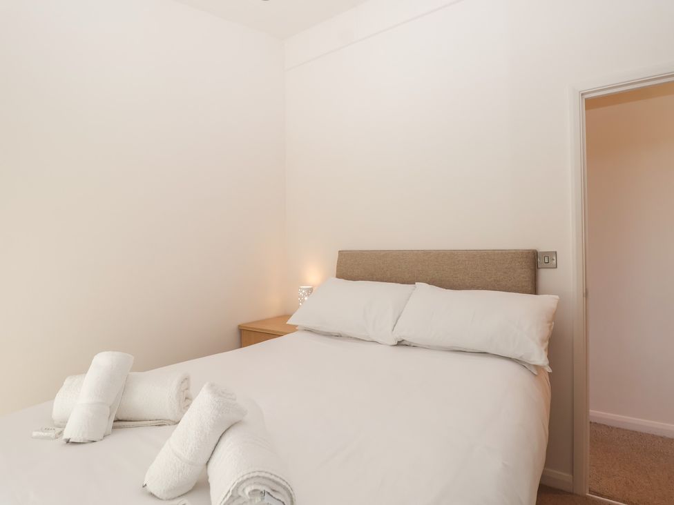 A bedroom with a bed and towels at Skyview in Newton Ferrers