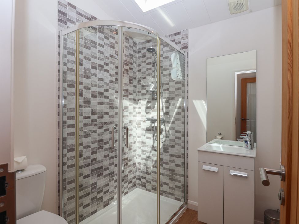 A bathroom with a shower, toilet, and sink at Skyview in Newton Ferrers