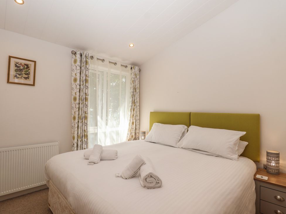 A bedroom with a bed and window at Skyview in Newton Ferrers