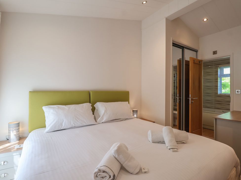 A bedroom with a bed and towels on the bed at Skyview in Newton Ferrers