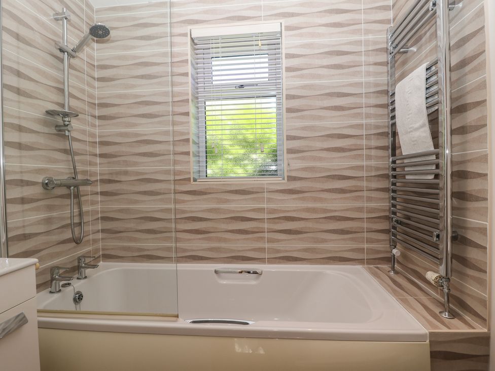 A bathroom with a bathtub and shower at Skyview in Newton Ferrers