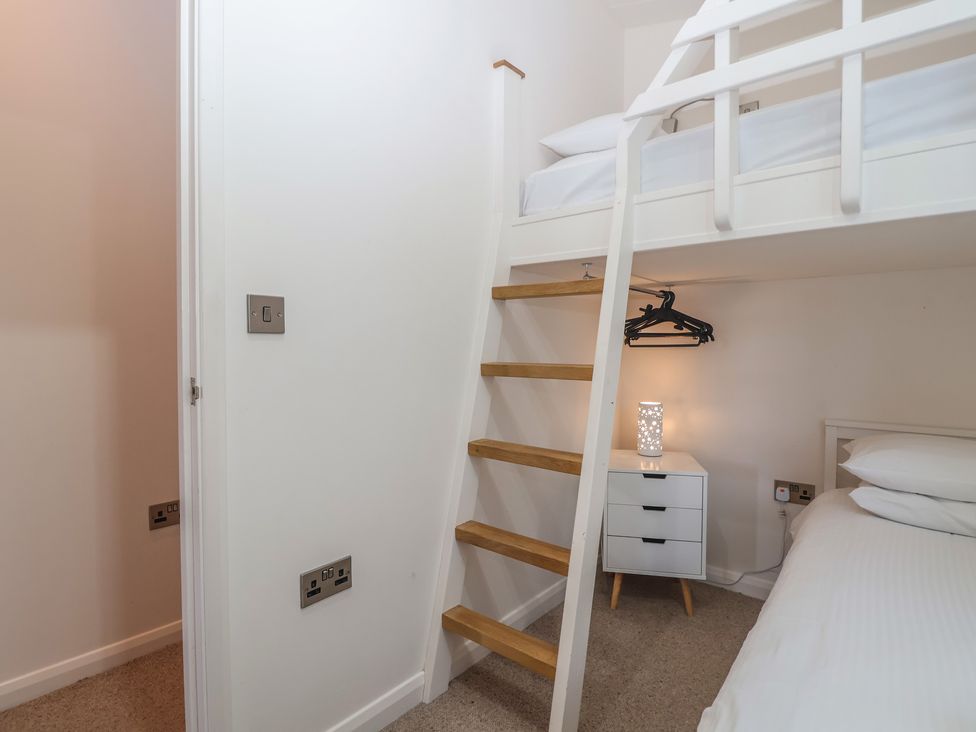 A bedroom with a bunk bed and nightstand at Skyview in Newton Ferrers