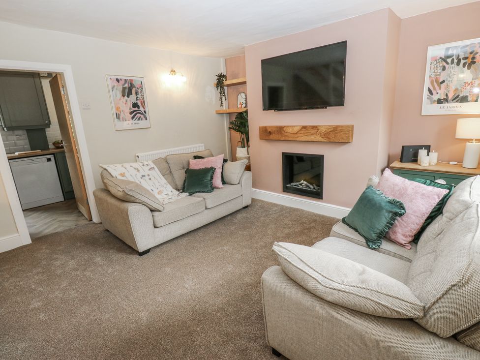 A living room with sofas and a television at Court Street Cottage Uppermill