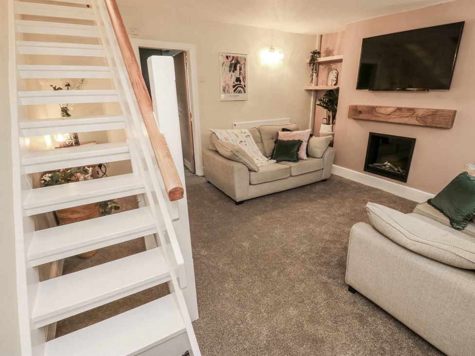 A living room with a sofa and television at Court Street Cottage in Uppermill