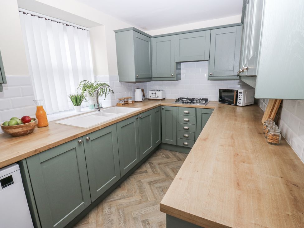 A kitchen with cabinets and countertop at Court Street Cottage Uppermill