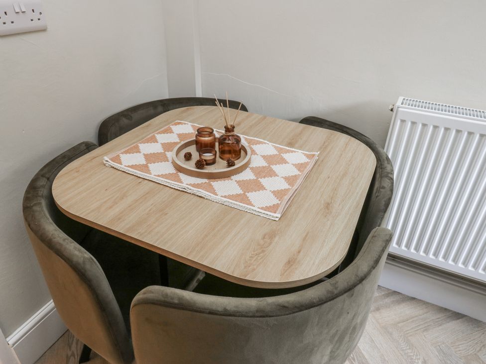 A dining table with chairs and candles at Court Street Cottage Uppermill