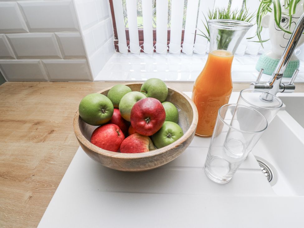 A bowl with apples and a carafe of orange juice at Court Street Cottage Uppermill