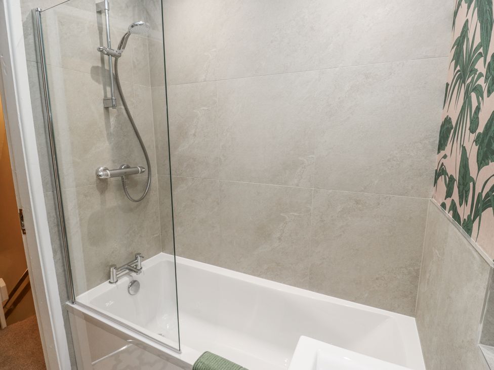 A bathroom with a bathtub and shower at Court Street Cottage Uppermill