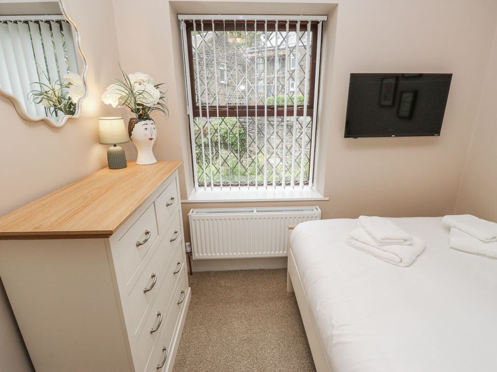 A bedroom with a bed and dresser at Court Street Cottage Uppermill