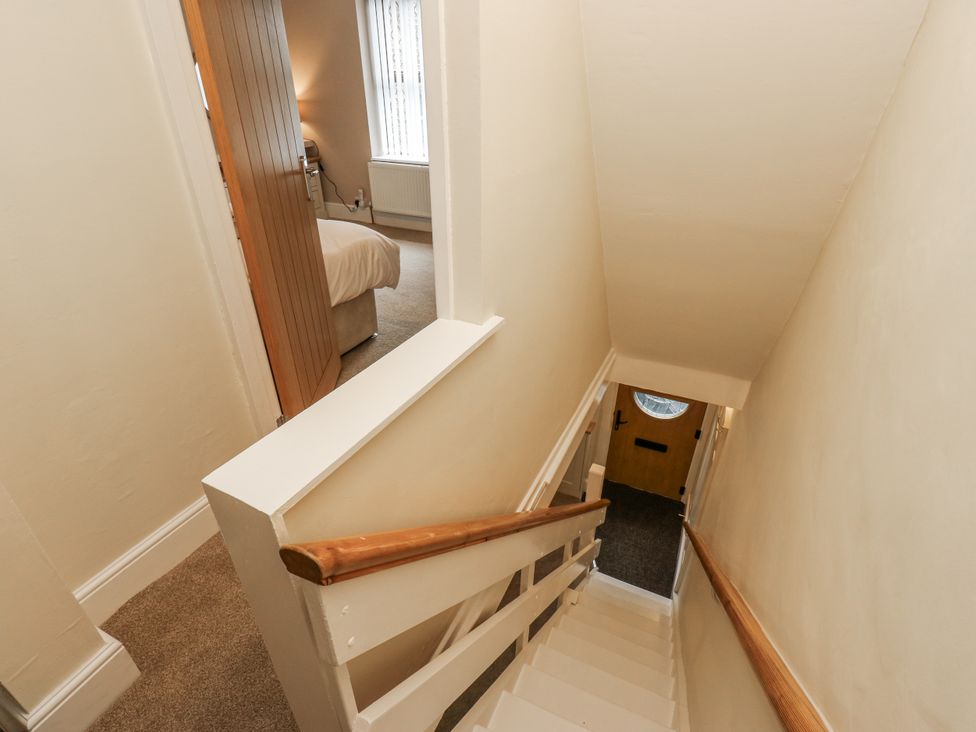 A stairwell with a staircase and a door at Court Street Cottage Uppermill