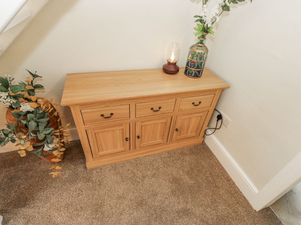 A console table with a lamp and decorative items at Court Street Cottage Uppermill