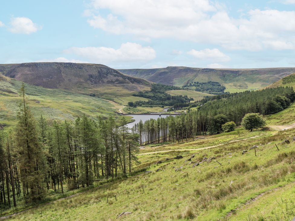 A landscape with hills, trees, and a lake at Court Street Cottage Uppermill