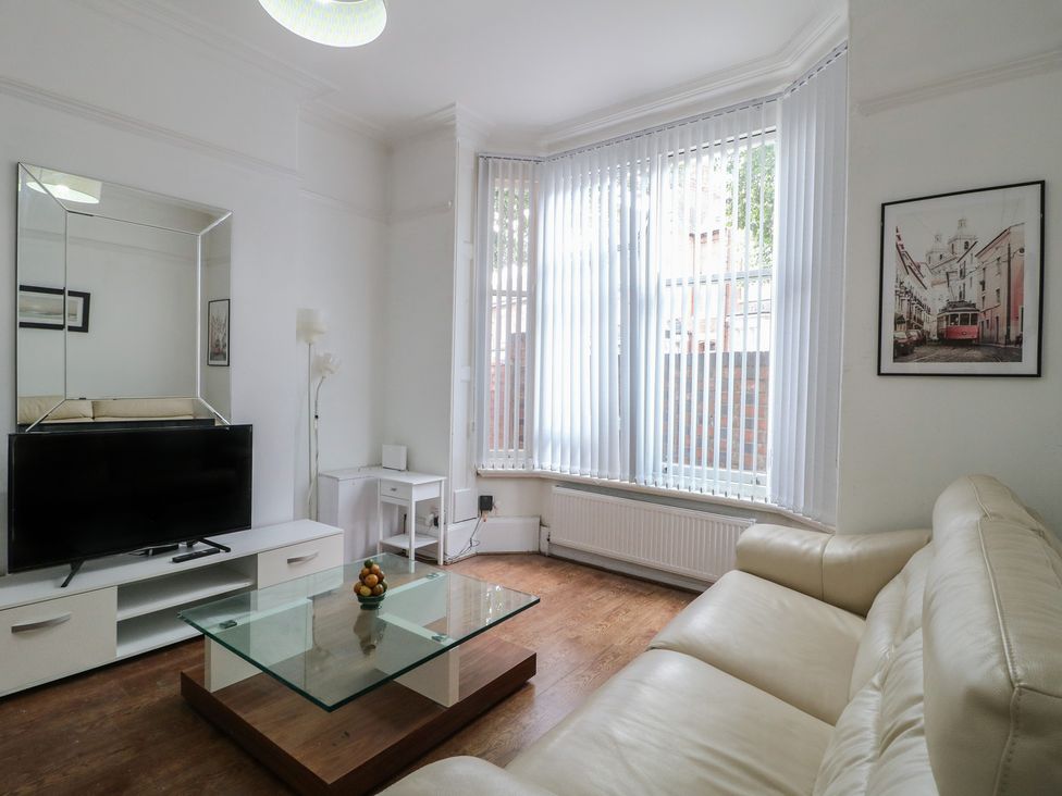 A living room with a TV and coffee table at 2 Evington Road