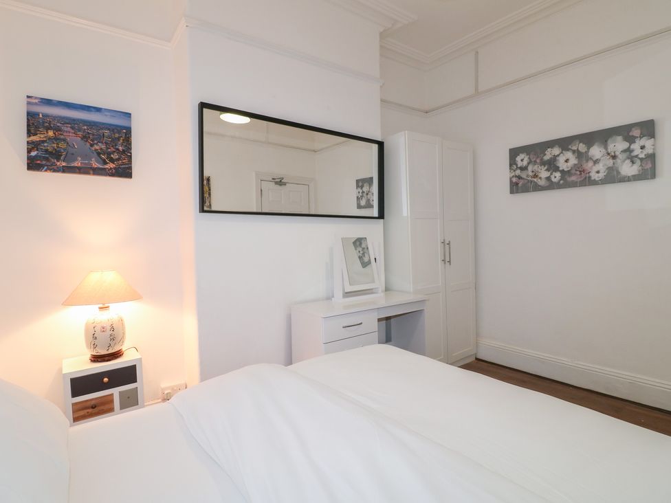 A bedroom with a bed, lamp, and desk at 2 Evington Road