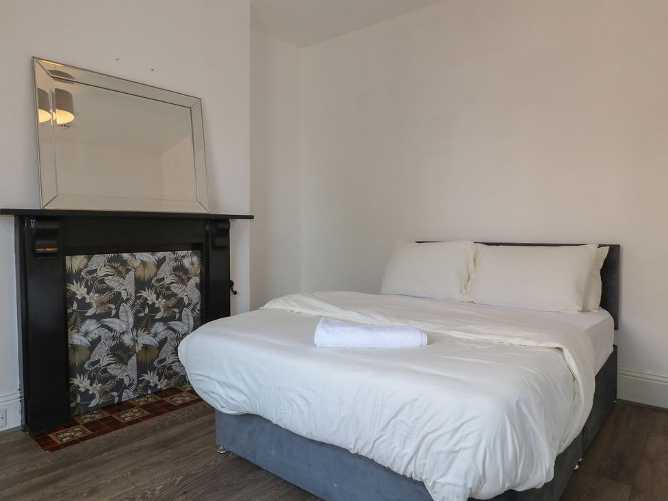 A bedroom with a bed and a mirror at 2 Evington Road