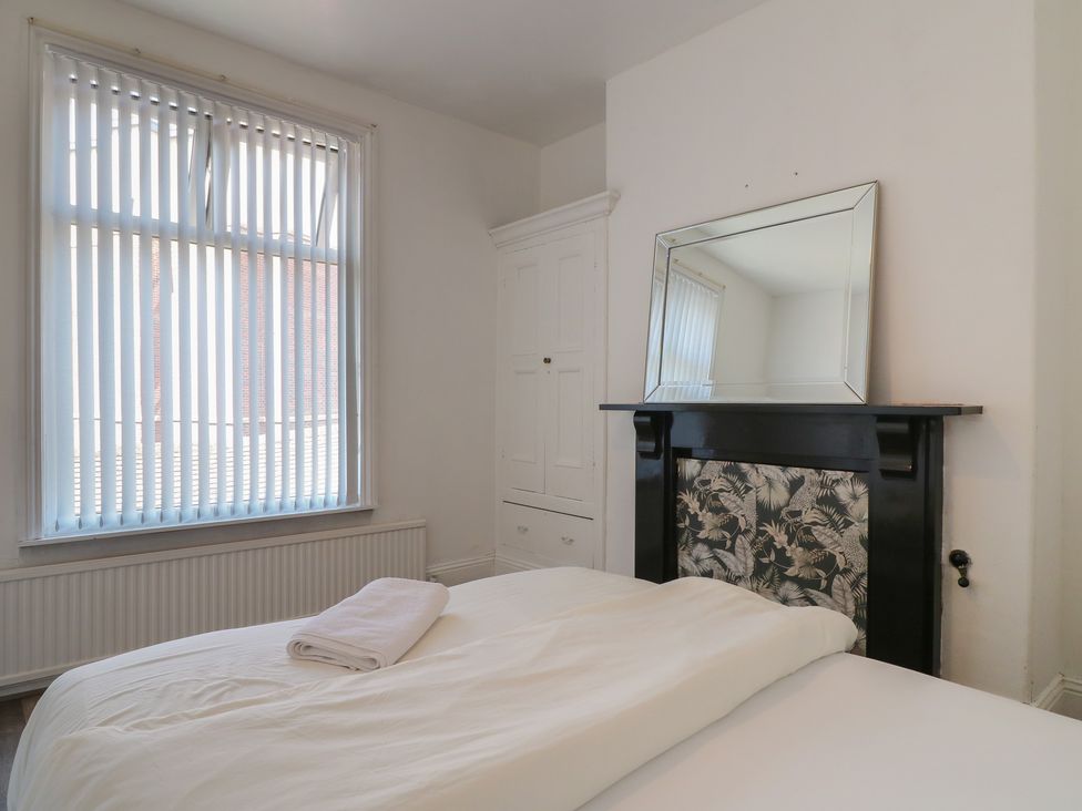 A bedroom with a bed and mirror at 2 Evington Road