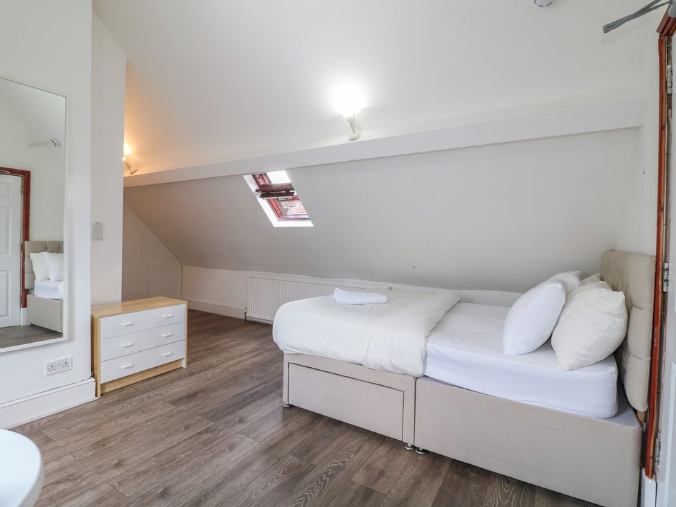 A bedroom with a bed and drawer unit at 2 Evington Road