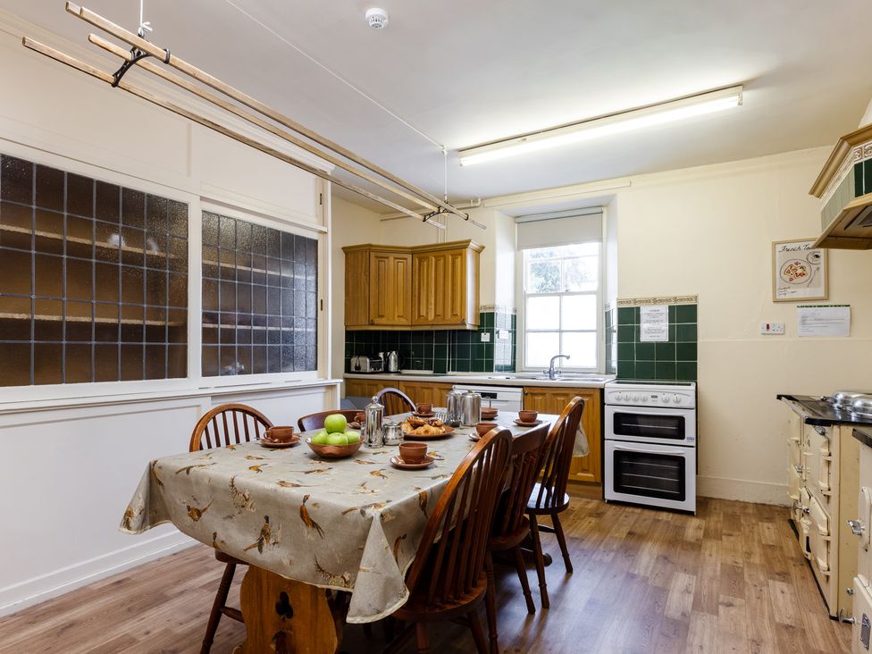 A kitchen with a table and chairs at Cheviot Manor in Akeld near Wooler