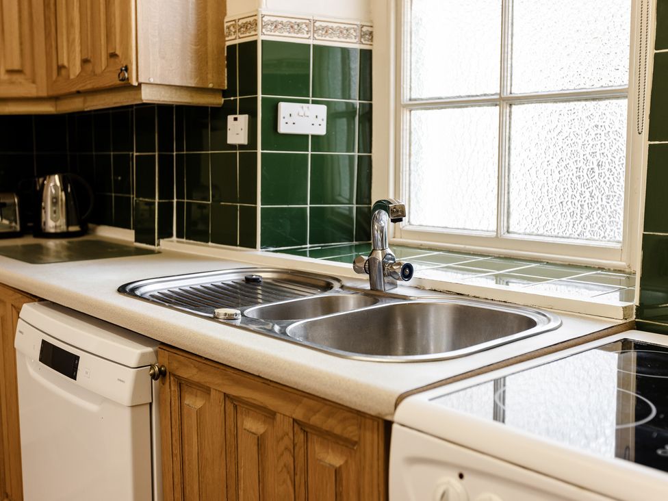 A kitchen with a sink and dishwasher at Cheviot Manor in Akeld near Wooler
