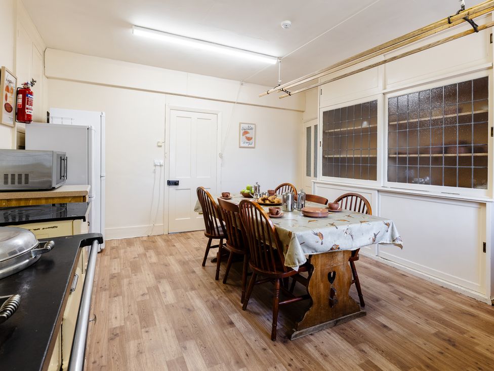A kitchen with a dining table and chairs at Cheviot Manor in Akeld near Wooler